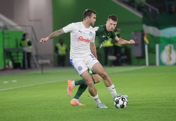 Marco Komenda (Holstein Kiel), Dzenan Pejcinovic (VfL Wolfsburg) Fussball, Saison 2025 2026, Maenner, Herren, DFB Pokal, 2. Hauptrunde, Volkswagenarena Wolfsburg, VfL Wolfsburg gegen Holstein Kiel DFL REGULATIONS PROHIBIT ANY USE OF PHOTOGRAPHS AS IMAGE SEQUENCES AND OR QUASI-VIDEO.