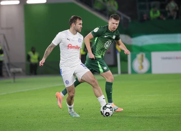 Marco Komenda (Holstein Kiel), Dzenan Pejcinovic (VfL Wolfsburg) Fussball, Saison 2025 2026, Maenner, Herren, DFB Pokal, 2. Hauptrunde, Volkswagenarena Wolfsburg, VfL Wolfsburg gegen Holstein Kiel DFL REGULATIONS PROHIBIT ANY USE OF PHOTOGRAPHS AS IMAGE SEQUENCES AND OR QUASI-VIDEO.