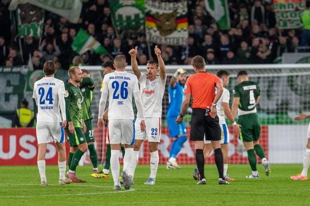 Deutschland, Fussball, DFB-Pokal, 2. Runde, 2025 2026, VfL Wolfsburg - Holstein Kiel am 28.10. in Wolfsburg (Volkswagen-Arena): Rote Karte Jenson Seelt (VfL Wolfsburg 14). Die Kieler feiern. Copyright: xSvenxHeidmannx