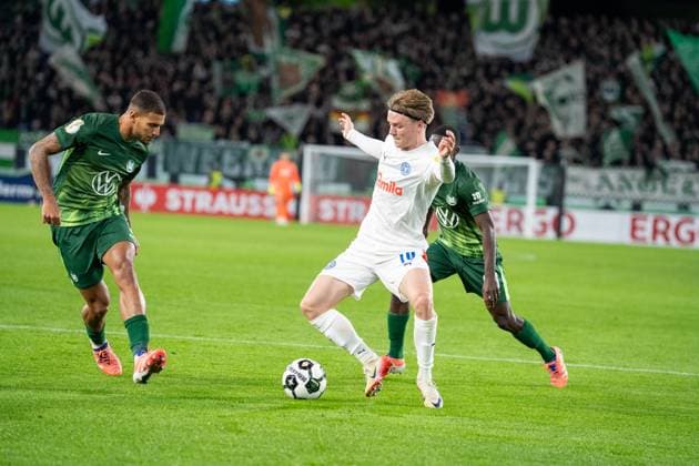 Deutschland, Fussball, DFB-Pokal, 2. Runde, 2025 2026, VfL Wolfsburg - Holstein Kiel am 28.10. in Wolfsburg (Volkswagen-Arena): Jonas Therkelsen (Holstein Kiel 10) Vinicius Souza (VfL Wolfsburg 5) und Sael Kumbedi (VfL Wolfsburg 26) Copyright: xSvenxHeidmannx