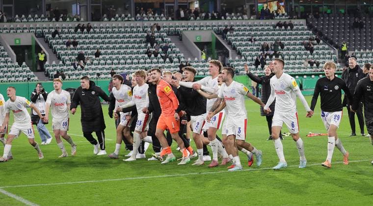 Kiel feiert mit der Welle den Sieg Fussball, Saison 2025 2026, Maenner, Herren, DFB Pokal, 2. Hauptrunde, Volkswagenarena Wolfsburg, VfL Wolfsburg gegen Holstein Kiel, 0-1 DFL REGULATIONS PROHIBIT ANY USE OF PHOTOGRAPHS AS IMAGE SEQUENCES AND OR QUASI-VIDEO.