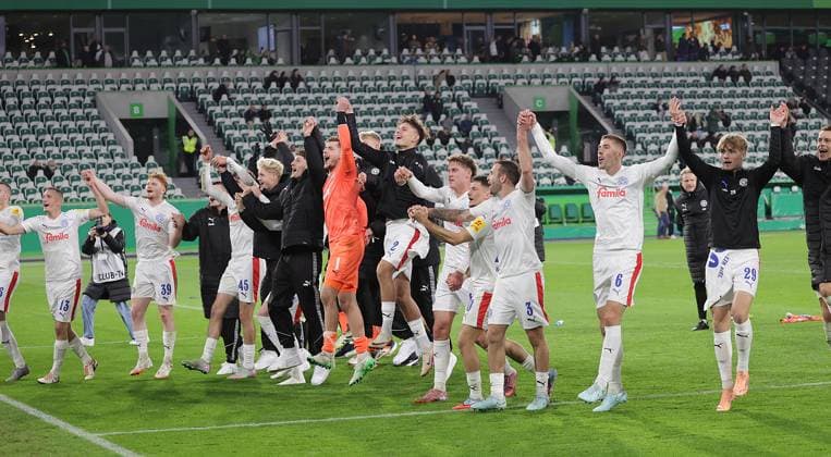 Kiel feiert mit der Welle den Sieg Fussball, Saison 2025 2026, Maenner, Herren, DFB Pokal, 2. Hauptrunde, Volkswagenarena Wolfsburg, VfL Wolfsburg gegen Holstein Kiel, 0-1 DFL REGULATIONS PROHIBIT ANY USE OF PHOTOGRAPHS AS IMAGE SEQUENCES AND OR QUASI-VIDEO.