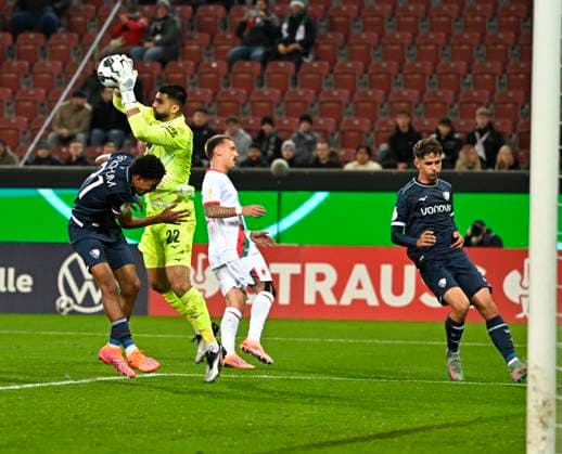28.10.2025, Fussball DFB-Pokal 2025 2026, 2.Runde, FC Augsburg - VfL Bochum, in der WWK-Arena Augsburg. Francis Onyeka (VfL Bochum) gegen Torwart Nediljko Labrovic (FC Augsburg) .