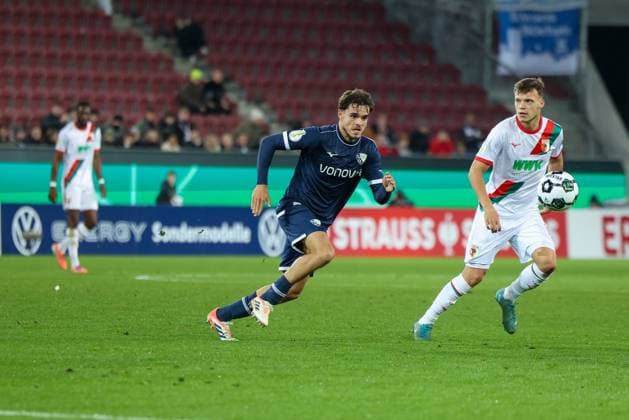 Duell eines Bochumer Spielers mit Robin Fellhauer 19 (FC Augsburg), FC Augsburg vs. VfL Bochum 1848, Fussball, Maenner, DFL, DFB-Pokal, Saison 2025 2026, WWK Arena, Zweite Runde, 28.10.2025 Augsburg Bayern Deutschland