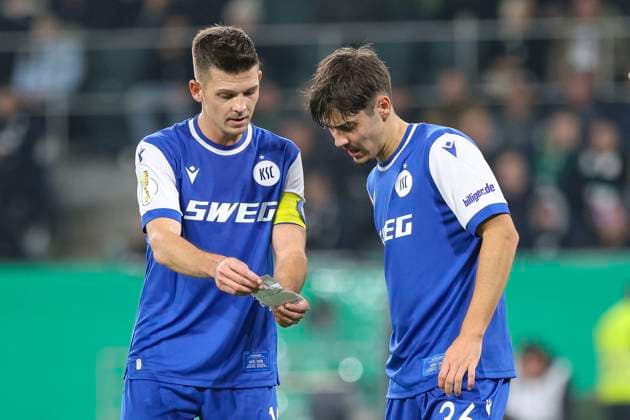 Mönchengladbach, Deutschland, 28.10.25: Marvin Wanitzek (Karlsruher SC) und Rafael Pinto Pedrosa (Karlsruher SC) lesen einen Zettel waehrend des Spiels der DFB-Pokal 2. Runde zwischen Borussia Mönchengladbach vs Karlsruher SC im Stadion im Borussia Park Mönchengladbach Stadion im Borussia Park North Rhine-Westphalia Germany Copyright: xBrauer-Fotoagenturx xAdrianxSchlx