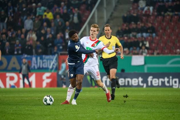 Deutschland: DFB-Pokal 2025 26, 2. Runde - FC Augsburg vs VfL Bochum - WWK Arena (Augsburg): Anton Kade, (FC Augsburg, 30) im Zweikampf mit Moritz‘Broni Kwarteng Moritz Broni Kwarteng, (VfL Bochum, 11) Augsburg WWK Arena Bayern Deutschland Copyright: xBenedictxChristx
