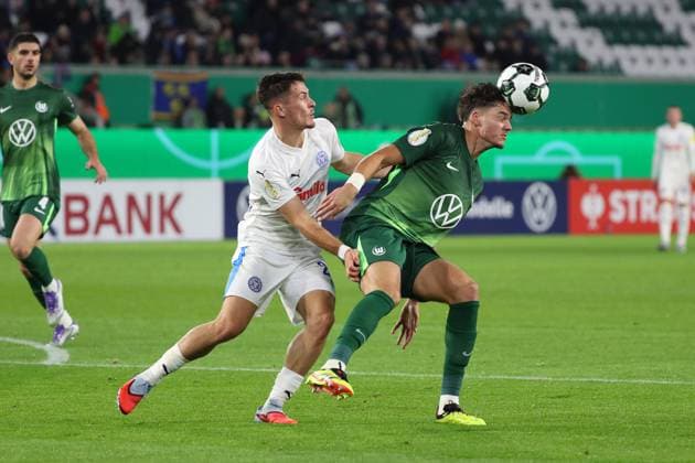 VfL vs. Kiel, 2. Runde DFB Pokal Wolfsburg, 28.10.2025, FUßBALL - VfL Wolfsburg vs. Holstein Kiel, 2. Runde DFB Pokal, Saison 2025 26. Adrian Kapralik (Holstein Kiel), Jenson Seelt (VfL Wolfsburg) Wolfsburg
