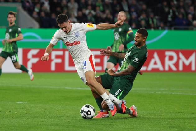 VfL vs. Kiel, 2. Runde DFB Pokal Wolfsburg, 28.10.2025, FUßBALL - VfL Wolfsburg vs. Holstein Kiel, 2. Runde DFB Pokal, Saison 2025 26. Adrian Kapralik (Holstein Kiel), Vinicius Vini Souza (VfL Wolfsburg) Wolfsburg