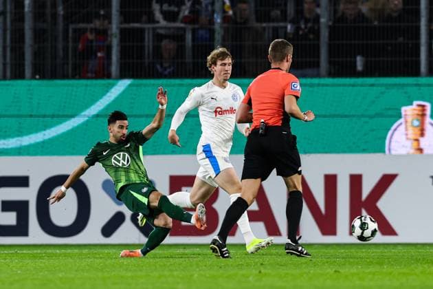 Mohamed Amoura (VfL Wolfsburg,9) gegen Lasse Rosenboom (Holstein Kiel,23) - 2. Runde DFB Pokal Saison 2025-2026 VfL Wolfsburg vs. Holstein Kiel in der Volkswagen Arena in Wolfsburg - Aktion,Fussball,Deutschland,Mann,Männer,28.10.2025