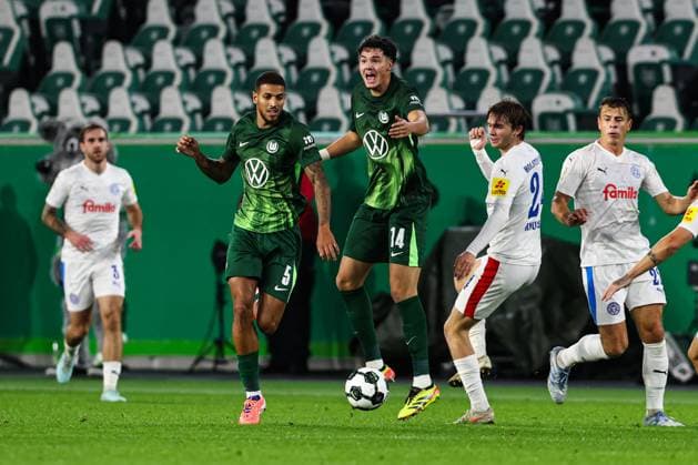 v.l. Vinicius Souza (VfL Wolfsburg,5), Jenson Seelt (VfL Wolfsburg,14), Magnus Knudsen (Holstein Kiel,24) - 2. Runde DFB Pokal Saison 2025-2026 VfL Wolfsburg vs. Holstein Kiel in der Volkswagen Arena in Wolfsburg - Aktion,Fussball,Deutschland,Mann,Männer,28.10.2025