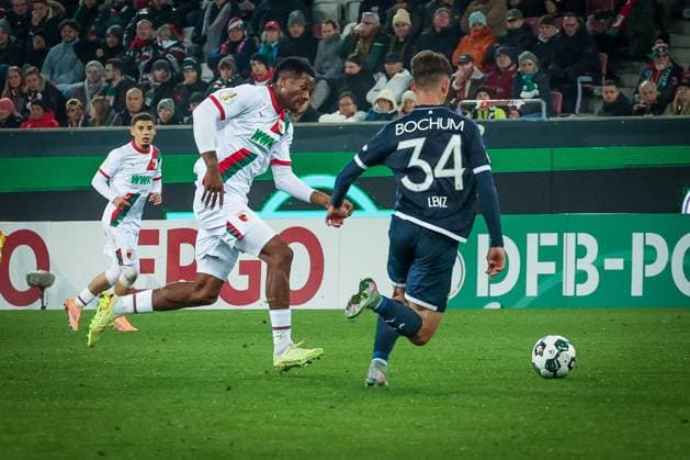 Samuel Essende 9 (FC Augsburg), links, gegen Cajetan Lenz 34 (VfL Bochum), FC Augsburg vs. VfL Bochum 1848, Fussball, Maenner, DFL, DFB-Pokal, Saison 2025 2026, WWK Arena, Zweite Runde, 28.10.2025 Augsburg Bayern Deutschland