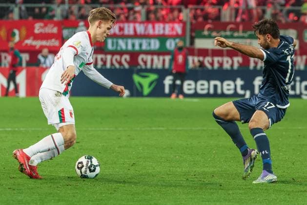 Anton Kade 30 (FC Augsburg), links, im Duell mit Gerrit Holtmann 17 (VfL Bochum), FC Augsburg vs. VfL Bochum 1848, Fussball, Maenner, DFL, DFB-Pokal, Saison 2025 2026, WWK Arena, Zweite Runde, 28.10.2025 Augsburg Bayern Deutschland