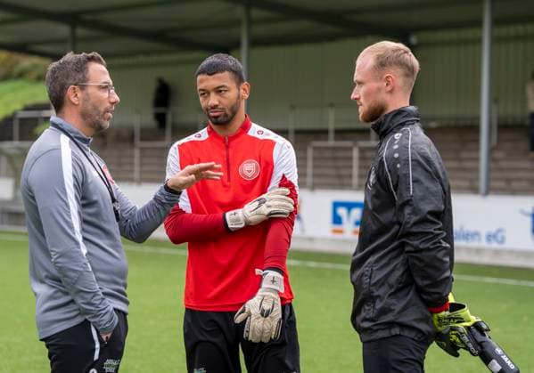 Boris Schommers (Sportfreunde Siegen, Trainer) li. im Gespräch mit Justin Ospelt (Sportfreunde Siegen, 1) mi. und Leon Klußmann (Sportfreunde Siegen, 21) re. Erste Trainingseinheit vom neuen Cheftrainer Boris Schimmers bei Sportfreunde Siegen 29.10.2025 Fussball, Regionalliga West, GER, Siegen, Leimbachstadion Nebenplatz Siegen Copyright: HMBxMedia xMarcoxBader