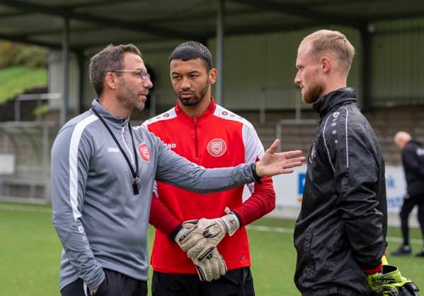 Boris Schommers (Sportfreunde Siegen, Trainer) li. im Gespräch mit Justin Ospelt (Sportfreunde Siegen, 1) mi. und Leon Klußmann (Sportfreunde Siegen, 21) re. Erste Trainingseinheit vom neuen Cheftrainer Boris Schimmers bei Sportfreunde Siegen 29.10.2025 Fussball, Regionalliga West, GER, Siegen, Leimbachstadion Nebenplatz Siegen Copyright: HMBxMedia xMarcoxBader