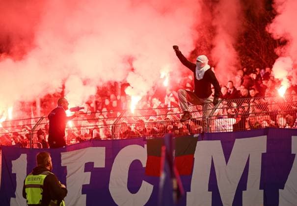 Fussball DFB Pokal 2025 2026 2. Runde 29.10.2025 FV Illertissen - 1. FC Magdeburg Die Utras 1. FC Magdeburg jubeln mit Pyros im Gaestefanblock nach dem Tor zum 0-1 ein vermummter Fan sitzt auf dem Zaun *** Soccer DFB Cup 2025 2026 2 round 29 10 2025 FV Illertissen 1 FC Magdeburg The Utras 1 FC Magdeburg cheer with pyros in the Gaestefanblock after the goal to 0 1 a hooded fan sits on the fence