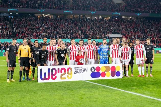 29.10.2025, Fussball: DFB Pokal, Saison 2025 2026, 2. Runde, 1. FC Koeln vs. FC Bayern Muenchen im RheinEnergie Stadion in Koeln. Die Mannschaften haben sich hinter dem Bewerbungsbanner aufgestellt. Wichtiger Hinweis: Gemaess den Vorgaben der DFL Deutsche Fussball Liga bzw. des DFB Deutscher Fussball-Bund ist es untersagt, in dem Stadion und oder vom Spiel angefertigte Fotoaufnahmen in Form von Sequenzbildern und oder videoaehnlichen Fotostrecken zu verwerten bzw. verwerten zu lassen. Foto: Kirchner-Media Thomas Haesler Copyright: xKirchner-Media ThomasxHaeslerx