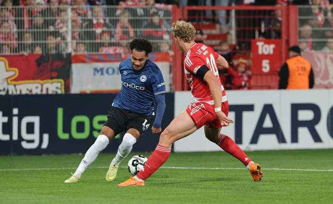 Monju Momuluh, Leopold Querfeld Zweikampf Spielszene Aktion Fußball Fussball DFB Pokal 2.Runde Herren Saison 2025 2026 29.10.2025 1.FC Union Berlin FCU vs. DSC Arminia Bielefeld DFL regulations prohibit any use of photographs as image sequences and or quasi-video.