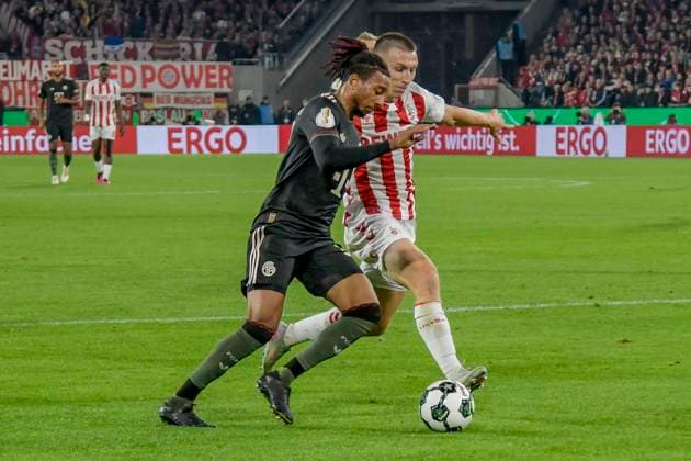v. li. im Zweikampf Michael Olise (Muenchen 17) Kristoffer Lund (Koeln 32) 29.10.2025 Fussball 1. FC Koeln vs FC Bayern Muenchen, Rheinenergiestadion, Koeln, DFB DFL REGULATIONS PROHIBIT ANY USE OF PHOTOGRAPHS AS IMAGE SEQUENCES AND OR QUASI-VIDEO