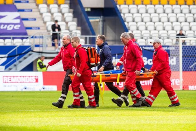 Jena , 311025, Fussball Regionalliga , FC Carl-Zeiss Jena gegen FC Magdeburg II im Bild: Manasse Eshele (Jena) verletzt auf der Trage neben FCC Mannschafts Arzt Dr. Stefan Pietsch