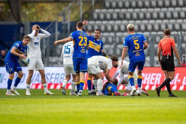 Jena , 311025, Fussball Regionalliga , FC Carl-Zeiss Jena gegen FC Magdeburg II im Bild: Manasse Eshele (Jena) liegt verletzt auf dem Rasen Andi Hoti (Magdeburg) mit dem er zusammengestossen war steht daneben