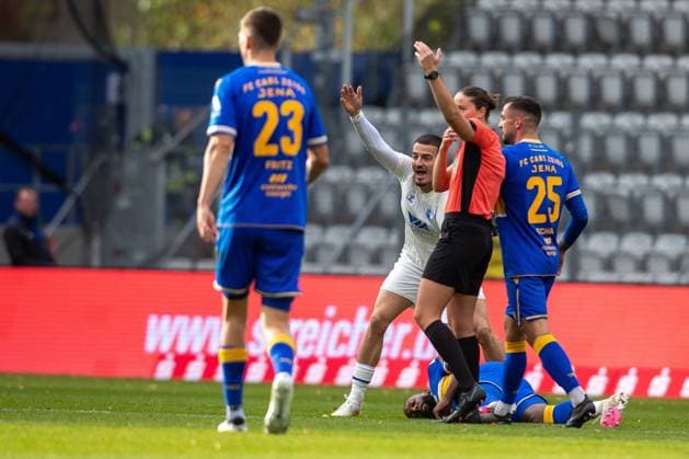 Jena , 311025, Fussball Regionalliga , FC Carl-Zeiss Jena gegen FC Magdeburg II im Bild: Manasse Eshele (Jena) liegt verletzt auf dem Rasen Andi Hoti (Magdeburg) mit dem er zusammengestossen war steht daneben