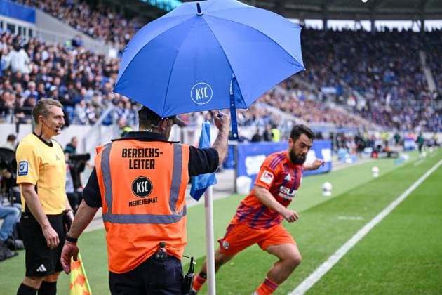 01.11.2025, Fussball, 2. Bundesliga, Saison 2025 2026, 11. Spieltag, Karlsruher SC - FC Schalke 04, Amin Younes (FC Schalke 04) wird mit einem Regenschirm geschützt beim Eckball, xRHR-FOTO YYx