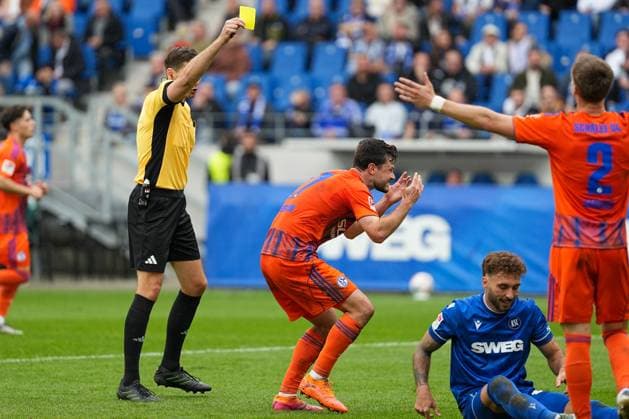 Fussball: 2. Bundesliga, 11. Spieltag, Karlsruher SC - FC Schalke 04 am 01.11.2025 in Karlsruhe (BBBank Wildpark), Deutschland, Saison 2025 2026 DFL REGULATIONS PROHIBIT ANY USE OF PHOTOGRAPHS AS IMAGE SEQUENCES AND OR QUASI VIDEO: Dr. Max Burda (Schiedsrichter) zeigt Adrian Gantenbein (17, S04) die Gelbe Karte. Karlsruhe BBBank Wildpark Deutschland