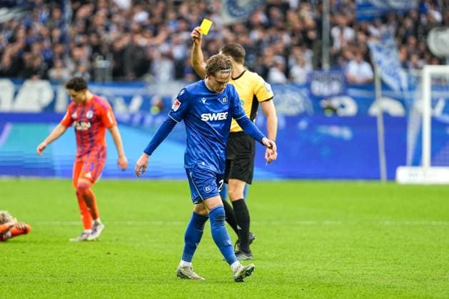 Fussball: 2. Bundesliga, 11. Spieltag, Karlsruher SC - FC Schalke 04 am 01.11.2025 in Karlsruhe (BBBank Wildpark), Deutschland, Saison 2025 2026 DFL REGULATIONS PROHIBIT ANY USE OF PHOTOGRAPHS AS IMAGE SEQUENCES AND OR QUASI VIDEO: Dr. Max Burda (Schiedsrichter) zeigt David Herold (20, KSC) die Gelbe Karte. Karlsruhe BBBank Wildpark Deutschland