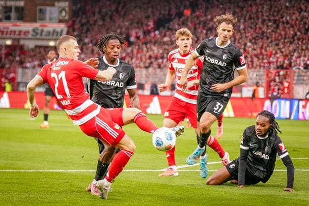 Deutschland: Fussball Bundesliga 2025 26, 9. Spieltag - 1. FC Union Berlin vs SC Freiburg - An der Alten Försterei (Berlin): Tim Skarke (1. FC Union Berlin, 21) Johan Manzambi (SC Freiburg, 44) Max Rosenfelder (SC Freiburg, 37) Copyright: xJOERANxSTEINSIEKx