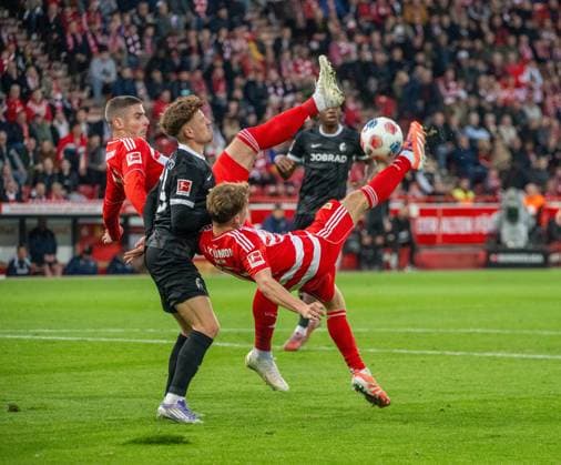 Fußball, Herren, Saison 2025 2026, 1. Bundesliga (9. Spieltag), 1. FC Union Berlin - SC Freiburg, v. l. Andrej Ilic (1. FC Union Berlin), Philipp Treu (Freiburg), Andras Schäfer (1. FC Union) mit Fallrückzieher, 01.11.2025, Copyright: xMatthiasxKochx