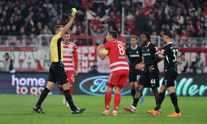 Schiedsrichter Sören Storks zeigt gelbe Karte für Rani Khedira Fußball Fussball Bundesliga Herren DFL 9. Spieltag Saison 2025 2026 01.11.2025 1.FC Union Berlin FCU vs. SC Freiburg SCF DFL regulations prohibit any use of photographs as image sequences and or quasi-video.