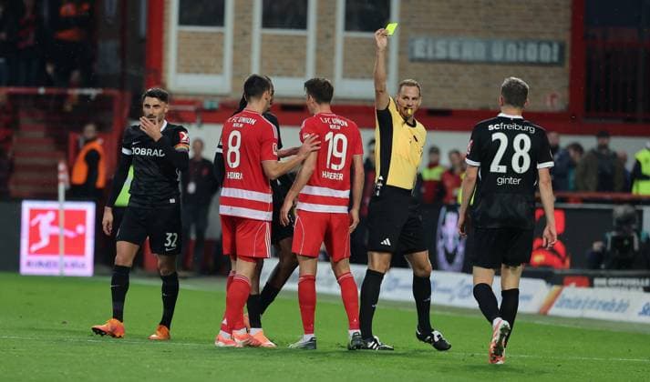Schiedsrichter Sören Storks zeigt gelbe Karte für Janik Haberer Fußball Fussball Bundesliga Herren DFL 9. Spieltag Saison 2025 2026 01.11.2025 1.FC Union Berlin FCU vs. SC Freiburg SCF DFL regulations prohibit any use of photographs as image sequences and or quasi-video.