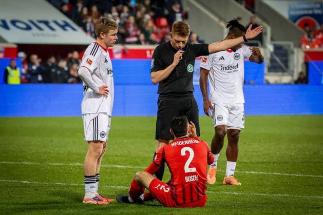 Referee Schiedsrichter Christian Dingert laesst die Betreuer auf den Platz fuer Marnon Busch 2 (1FC Heidenheim 1846), der danach verletzt raus muss, mit Jonathan Burkardt 9 (Eintracht Frankfurt), 1.FC Heidenheim 1846 vs. Eintracht Frankfurt, Fussball, Maenner, DFL, Bundesliga, Saison 2025 2026, Voith Arena, 9. Spieltag, 01.11.2025 Heidenheim Baden-Wuerttemberg Deutschland