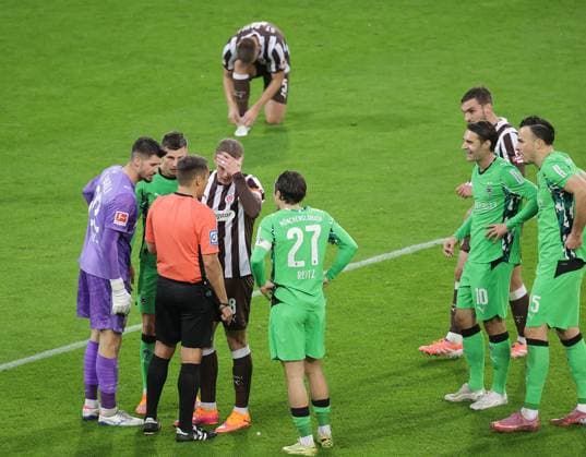 Diskussion mit Schiedsrichter Robert Hartmann nach dem 0-1 und VAR Torhueter Nikola Vasilj (FC St. Pauli), Eric Smith (FC St. Pauli), Rocco Reitz (Borussia Moenchengladbach) Fussball, 1.BL, Saison 2025 2026, Herren, FC St.Pauli gegen Borussia Moenchengladbach, Millerntor Stadion DFL REGULATIONS PROHIBIT ANY USE OF PHOTOGRAPHS AS IMAGE SEQUENCES AND OR QUASI-VIDEO.
