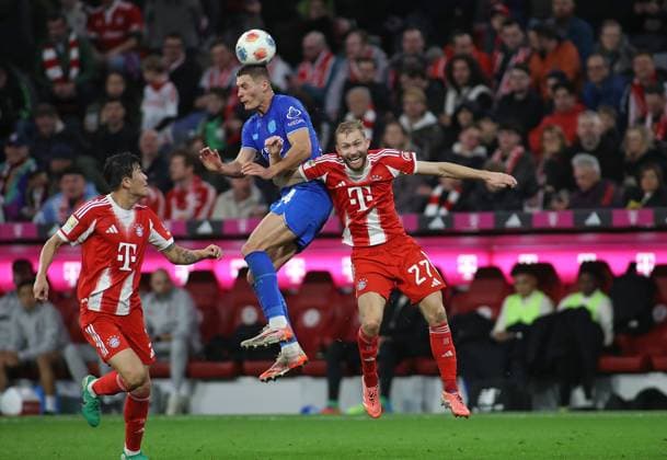 Fussball, Herren, Bundesliga, Saison 2025 2026, FC Bayern München - Bayer 04 Leverkusen, Allianz Arena Patrik Schick (Bayer 04 Leverkusen) (li.) mit Konrad Laimer (FC Bayern München) (re.) im Zweikampf um den Ball, Kopfballduell, Aktion DFB, DFL regulations prohibit any use of photographs as image sequences and or quasi-video