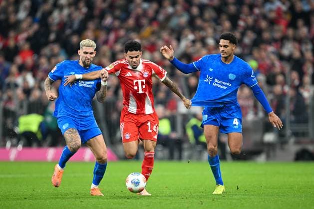 1. BL - 25 26 - FC Bayern München - Bayer 04 Leverkusen am 01.11.2025 in der Allianz Arena in Muenchen Luis Diaz (Bayern Muenchen) im Zweikampf gegen Jarell Quansah (Leverkusen) und Robert Andrich (Leverkusen)