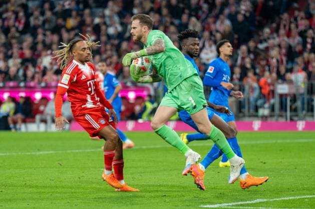 im Zweikampf, Aktion, mit Sascha Boey 23 (FC Bayern Muenchen), Mark Flekken 1 (Bayer 04 Leverkusen), FC Bayern Muenchen vs. Bayer 04 Leverkusen, Fussball, 1. Bundesliga, 9. Spieltag, 01.11.2025 DFB regulations prohibit any use of photographs as image sequences and or quasi-video Muenchen Bayern Deutschland