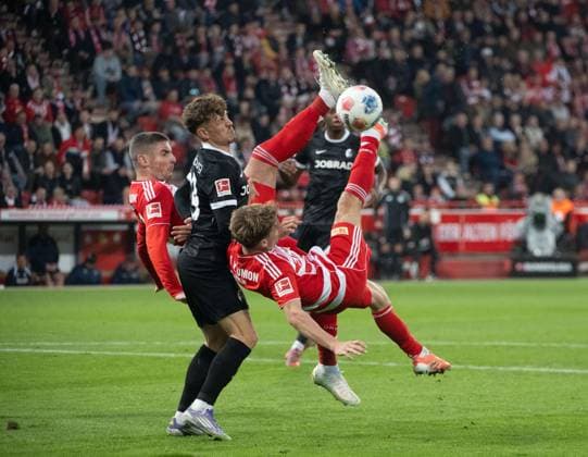 Fußball, Herren, Saison 2025 2026, 1. Bundesliga (9. Spieltag), 1. FC Union Berlin - SC Freiburg, v. l. Andrej Ilic (1. FC Union Berlin), Philipp Treu (Freiburg), Andras Schäfer (1. FC Union) mit Fallrückzieher, 01.11.2025, Copyright: xMatthiasxKochx