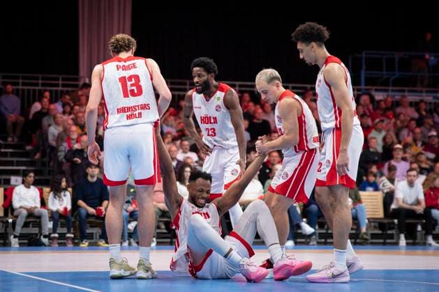 Barmer 2. Basketball Bundesliga ProA: RheinStars Koeln vs. Kirchheim, 02.11.25 Adam John Paige (RheinStars Köln, 13, PF) und Rupert Hennen (RheinStars Köln, 5, PG) helfen Hall B Elisias (RheinStars Köln, 34, C) auf; Köln, 02.11.25 - Barmer 2. Basketball Bundesliga ProA: RheinStars Koeln vs. Kirchheim in der Motor World in Köln. Copyright: xBEAUTIFULxSPORTS AxelxKohringx