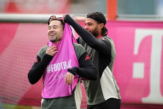 Fussball, Herren, Champions League, Saison 2025 2026, FC Bayern München, Abschlusstraining Raphael Guerreiro (FC Bayern München) (li.) bekommt von Serge Gnabry (FC Bayern München) (re.) das Leibchen über den Kopf gezogen