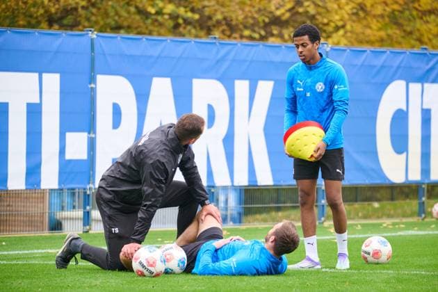 04.11.2025, Fußball, Herren, 2.BL, Saison 2025 2026, Training Holstein Kiel Marco Komenda wird von Athletiktrainer Timm Sörensen gedehnt - Andu Kelati dahinter Kiel, Projensdorf Projensdorf, Trainigsplatz, Rase Schleswig-Holstein Deutschland