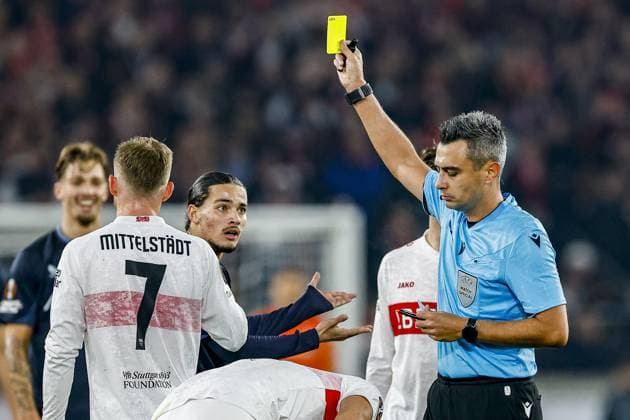 STUTTGART , 06-11-2025 , MHP Arena , season 2025 2026 , UEFA Europa League League phase match between Vfb Stuttgart and Feyenoord , Picture shows referee Horatiu Fesnic show the yellow card too Feyenoord player Anis Hadj Moussa Stuttgart - Feyenoord  x31892052x Copyright: