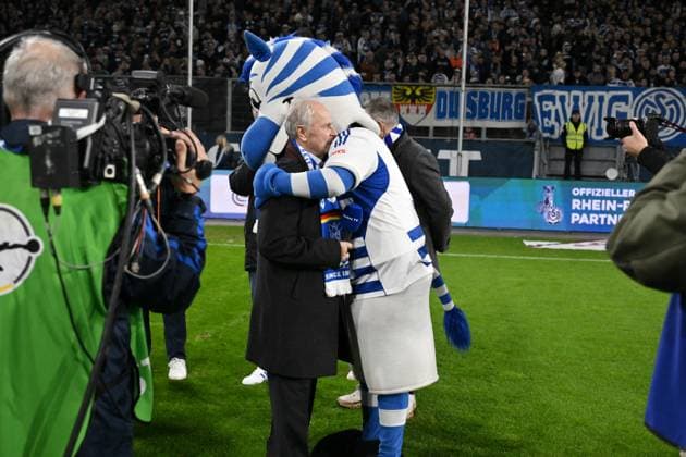 Umarmung zwischen Ennatz Dietz und Zebra Maskottchen ENNATZ. Bernard Dietz wurde vom DFB zum Ehrenspielführer der deutschen Nationalmannschaft ernannt. 07.11.2025, Fussball, 3. Liga, Saison 2025 26, 14. Spieltag, MSV Duisburg - SV Waldhof Mannheim 2:1 DFB regulations prohibit any use of photographs as image sequences and or quasi-video Duisburg Schauinsland Reisen Arena Nordrhein Westfalen Deutschland