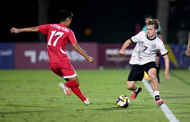 Fussball, Junioren U 17 WM 2025 in Doha Katar Vorrunde 07.11.2025 Gruppe G Deutschland - Korea DVR Kyong Bong Ri (li, Korea DVR) gegen Benjamin Ley (re, Deutschland)