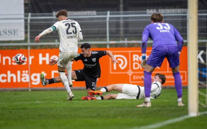 Fussball, Saison 2025 2026, Regionalliga West, 08.11.2025, 15. Spieltag, Herren, 1.FC Bocholt (schwarz) vs. Borussia Moenchengladbach U23 (weiss) v.l.: Lion Schweers (Borussia Moenchengladbach U23), Marvin Lorch (1.FC Bocholt), Yannick Michaelis (Borussia Moenchengladbach U23), Florian Dimmer (Torwart Borussia Moenchengladbach U23), Bocholt Stadion am Huenting Nordrhein-Westfalen Deutschland