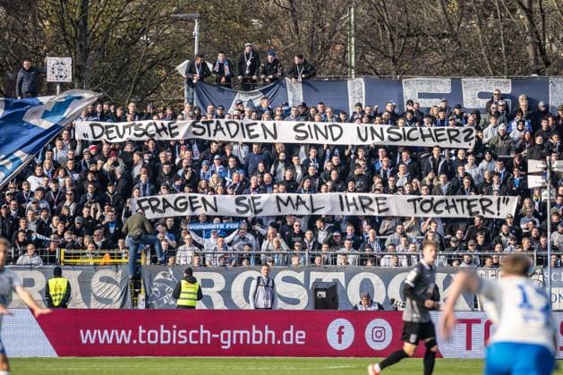 Fussball, Saison 2025 2026, 3. Liga, Donaustadion Ulm, 14. Spieltag, SSV Ulm 1846 Fußball - FC Hansa Rostock, 08.11.2025 08.11.2025, Fussball, Saison 2025 2026, 3. Liga, Donaustadion Ulm, 14. Spieltag, SSV Ulm 1846 Fußball - FC Hansa Rostock, Fanblock Gästeblock Fans FC Hansa Rostock Spruchband: Deutsche Stadien sind Unsicher? Fragen sie mal ihre Tochter! Foto: Lucca Fundel Ulm Donaustadion Baden-Württemberg Deutschland