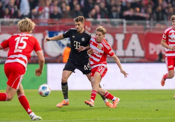 Duel between: Zweikampf zwischen: Josip Stanisic (FC Bayern Muenchen, 44) und Andras Schaefer (FC Union Berlin, 13) 08.11.2025, 1. FC Union Berlin - FC Bayern München, Fussball, 1. Bundesliga in Berlin, Stadion an der Alten Försterei DFL regulations prohibit any use of photographs as image sequences and or quasi-video. Copyright: HMBxMedia xMarcoxBader