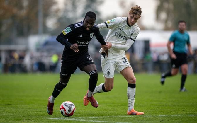 Fussball, Saison 2025 2026, Regionalliga West, 08.11.2025, 15. Spieltag, Herren, 1.FC Bocholt (schwarz) vs. Borussia Moenchengladbach U23 (weiss) v.l.: Johannes Doerfler (1.FC Bocholt), Niklas Swider (Borussia Moenchengladbach U23), Bocholt Stadion am Huenting Nordrhein-Westfalen Deutschland