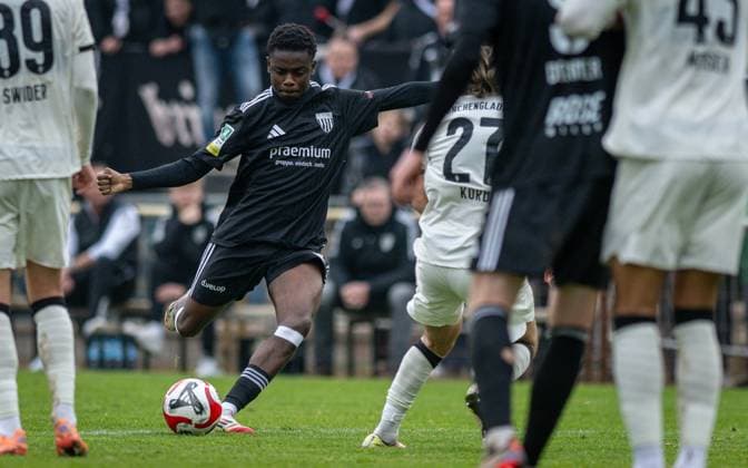 Fussball, Saison 2025 2026, Regionalliga West, 08.11.2025, 15. Spieltag, Herren, 1.FC Bocholt (schwarz) vs. Borussia Moenchengladbach U23 (weiss) v.l.: Aaron Bayakala (1.FC Bocholt), Julian Korb (Borussia Moenchengladbach U23), Bocholt Stadion am Huenting Nordrhein-Westfalen Deutschland