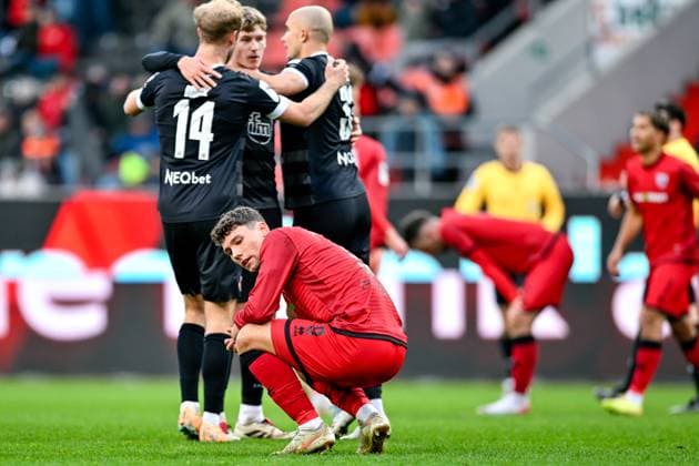 Mads Borchers (FC Ingolstadt, 9) nach Spielende enttaeuscht schauend, Enttaeuschung, Frustration, disappointed, pessimistisch, dahinter bejubeln die Essener Spieler den Sieg, 08.11.2025, Ingolstadt (Deutschland), Fussball, 3. Liga, FC Ingolstadt 04 - Rot-Weiss Essen, DFB DFL REGULATIONS PROHIBIT ANY USE OF PHOTOGRAPHS AS IMAGE SEQUENCES AND OR QUASI-VIDEO.